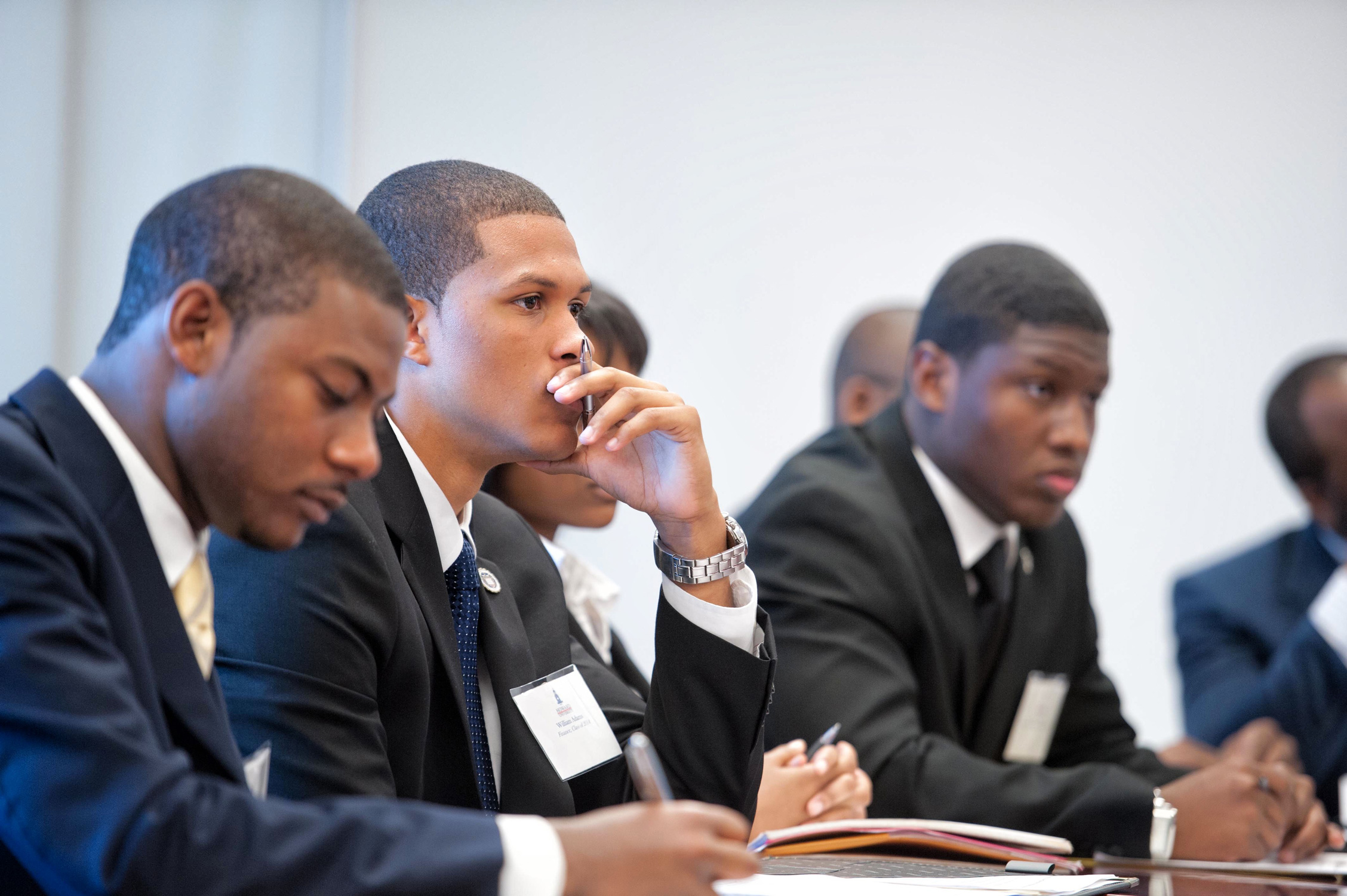 Students in suits sitting at a lecture.
