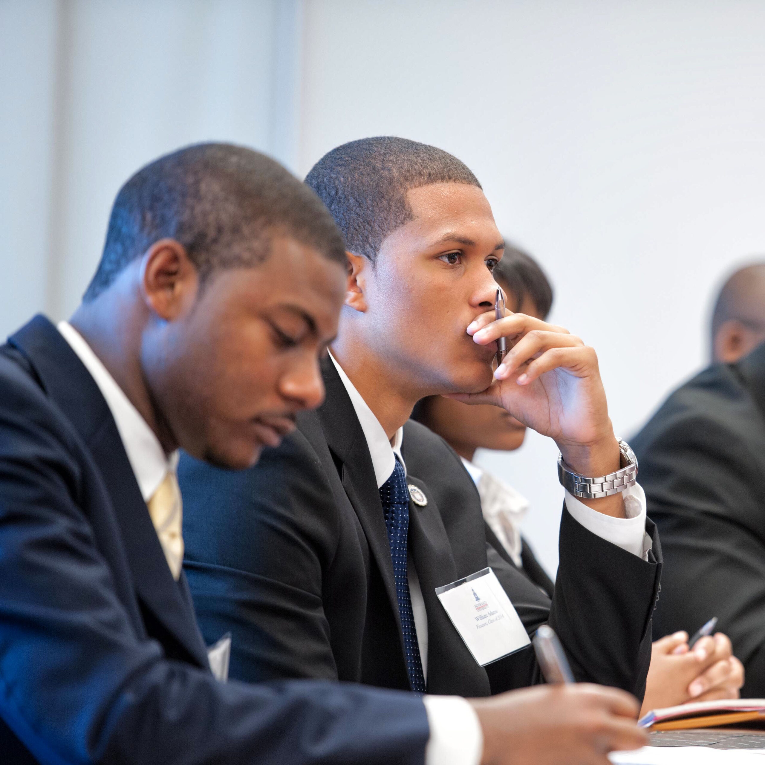 Students in suits sitting at a lecture.